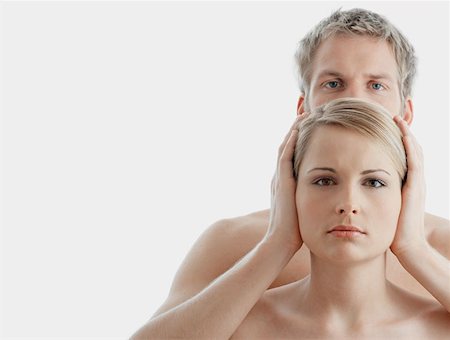 Man covering woman's ears Stock Photo - Premium Royalty-Free, Code: 614-00654399