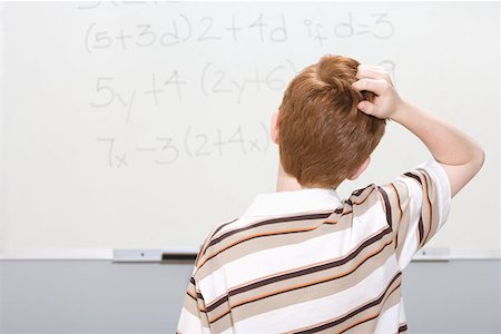 scratching head - Boy puzzled by maths problem Stock Photo - Premium Royalty-Free, Code: 614-00654665