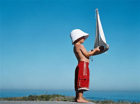 Boy holding toy boat Stock Photo - Premium Royalty-Free, Code: 614-00655011