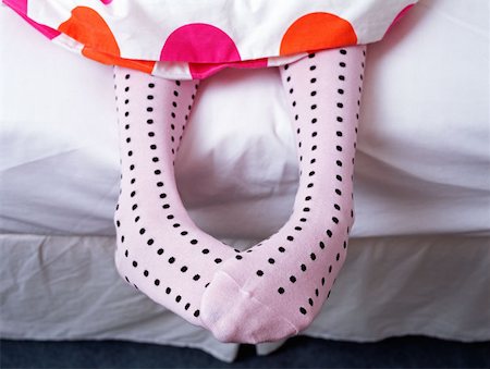 Feet hanging out of bed Stock Photo - Premium Royalty-Free, Code: 614-00655498