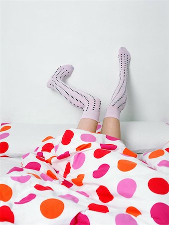 socks feet - Legs in socks poking out of bed Stock Photo - Premium Royalty-Free, Code: 614-00655520
