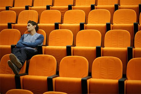 Drowsy young man alone in lecture theatre Stock Photo - Premium Royalty-Free, Code: 614-00655649