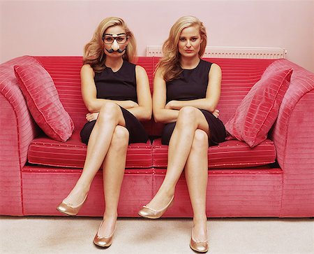 simsearch:614-09276674,k - Two women on a sofa one wearing a comedy disguise Stock Photo - Premium Royalty-Free, Code: 614-00657110