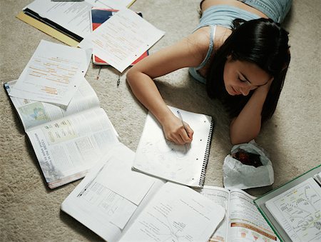 Girl doing homework on floor Stock Photo - Premium Royalty-Free, Code: 614-00653382