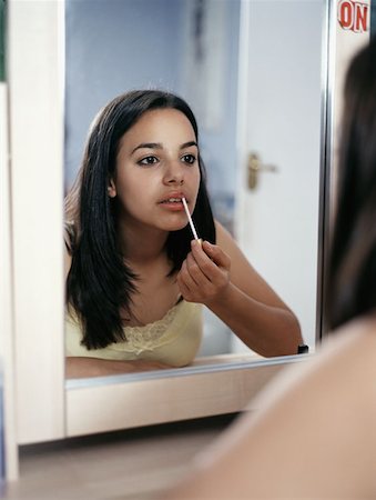 Girl applying lipgloss Foto de stock - Sin royalties Premium, Código: 614-00653414