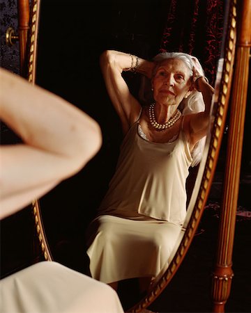 Senior woman looking in a mirror Stock Photo - Premium Royalty-Free, Code: 614-00653570