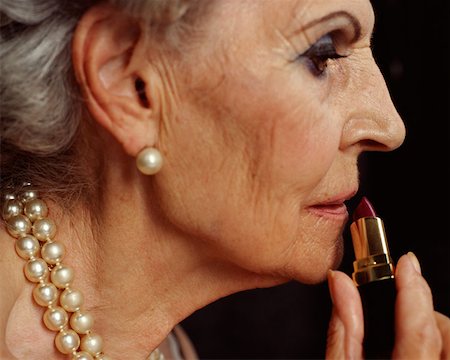 Senior woman applying lipstick Stock Photo - Premium Royalty-Free, Code: 614-00653609