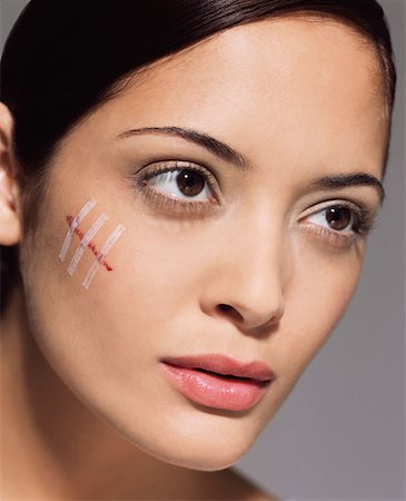 Woman with cut on her face Stock Photo - Premium Royalty-Free, Code: 614-00684018