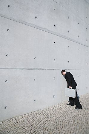 frustrated man with briefcase - Businessman with his head against a wall Stock Photo - Premium Royalty-Free, Code: 614-00683616