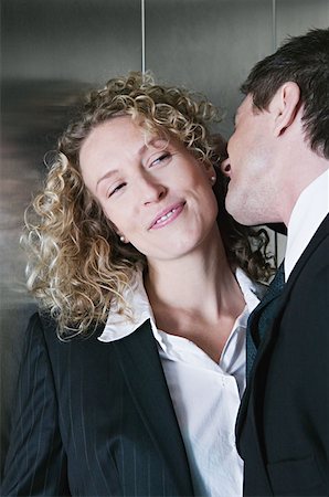 smiling businessman in elevator - Businessman and businesswoman flirting Stock Photo - Premium Royalty-Free, Code: 614-00683619