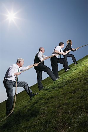 Business people climbing hill with rope Stock Photo - Premium Royalty-Free, Code: 614-00683644