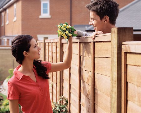 Man giving flowers to his neighbour Stock Photo - Premium Royalty-Free, Code: 614-00694358