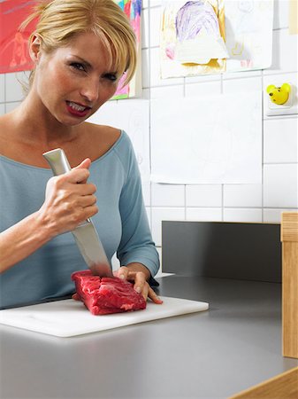 frustrated cook - Angry woman cutting beef Stock Photo - Premium Royalty-Free, Code: 614-00694755