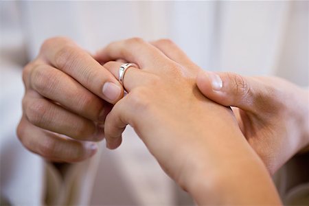 Groom placing wedding ring on brides finger Stock Photo - Premium Royalty-Free, Code: 614-00778248