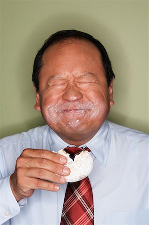 simsearch:614-02258138,k - Businessman eating a doughnut Stock Photo - Premium Royalty-Free, Code: 614-00844043