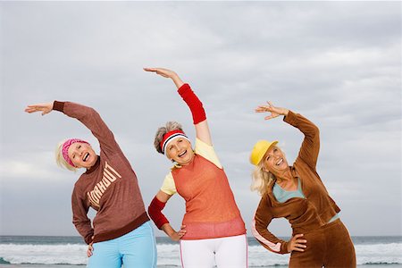 senior women stretching on beach - Three senior women stretching on beach Stock Photo - Premium Royalty-Free, Code: 614-00892338