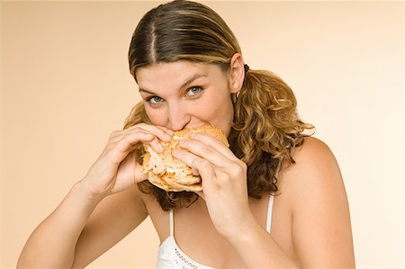 simsearch:614-02258138,k - Woman eating a burger Stock Photo - Premium Royalty-Free, Code: 614-00892463