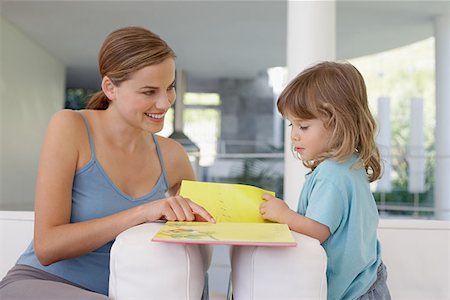 Mother helping her daughter to read Stock Photo - Premium Royalty-Free, Code: 614-00892635