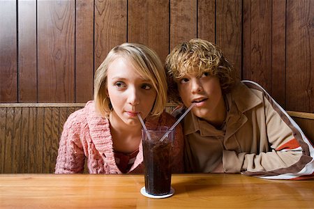 Teenage couple sharing a soft drink Stock Photo - Premium Royalty-Free, Code: 614-00893329