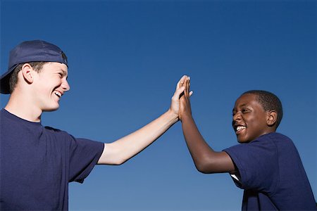 Two teenage boys giving a high five Stock Photo - Premium Royalty-Free, Code: 614-00893832