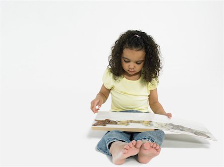 Girl reading a storybook Stock Photo - Premium Royalty-Free, Code: 614-01028693