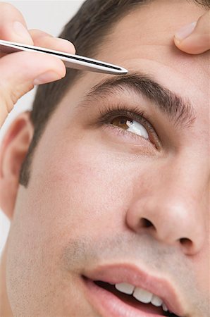 plucked - Man plucking his eyebrows Foto de stock - Sin royalties Premium, Código: 614-01088173