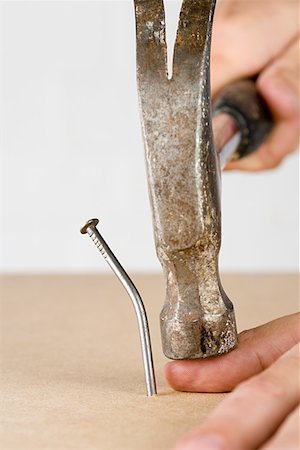 Person hitting thumb with hammer Stock Photo - Premium Royalty-Free, Code: 614-01088510