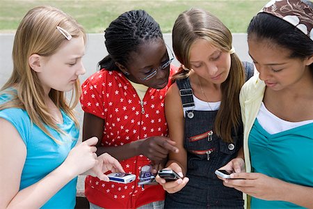 Girls looking at mobile phones Stock Photo - Premium Royalty-Free, Code: 614-01118067