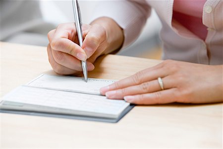 Woman writing a cheque Fotografie stock - Premium Royalty-Free, Codice: 614-01178539