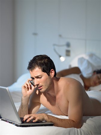 Man working as wife sleeps Foto de stock - Sin royalties Premium, Código: 614-01170536