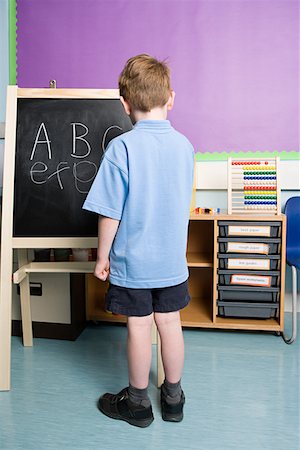 Boy writing on blackboard Stock Photo - Premium Royalty-Free, Code: 614-01171248