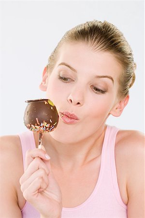 Woman eating chocolate apple Stock Photo - Premium Royalty-Free, Code: 614-01219562