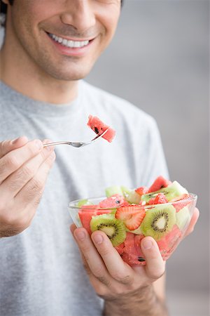 Man eating a fruit salad Stock Photo - Premium Royalty-Free, Code: 614-01237414