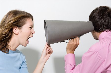 Woman shouting down megaphone Stock Photo - Premium Royalty-Free, Code: 614-01268116