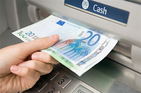 Person withdrawing cash Fotografie stock - Premium Royalty-Free, Codice: 614-01433303