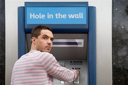 simsearch:614-01433346,k - Man looking over shoulder at cash machine Foto de stock - Royalty Free Premium, Número: 614-01433374