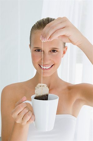 saquinho de chá - Young woman holding tea bag Foto de stock - Royalty Free Premium, Número: 614-01560191