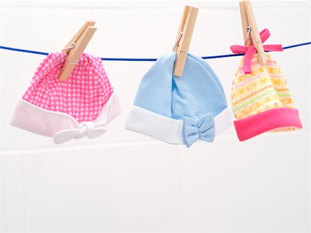 ropas para guaguas - Baby bonnets on washing line Foto de stock - Sin royalties Premium, Código: 614-01560438