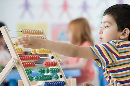 A boy counting on abacus Foto de stock - Royalty Free Premium, Número: 614-01634699