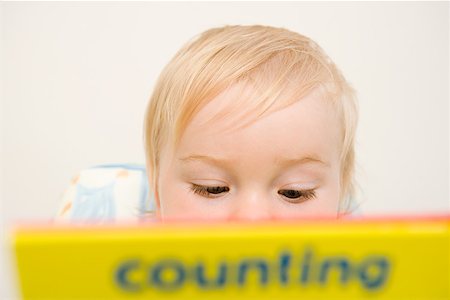 Baby boy looking at a book Stock Photo - Premium Royalty-Free, Code: 614-01699796