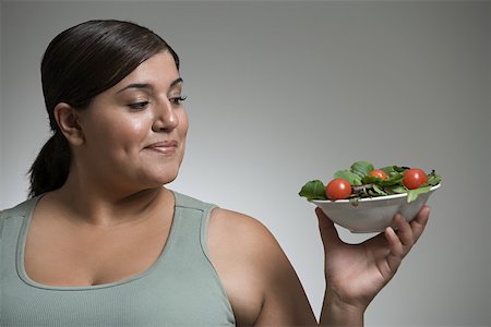 Woman looking at bowl of salad Stock Photo - Premium Royalty-Free, Code: 614-01700732