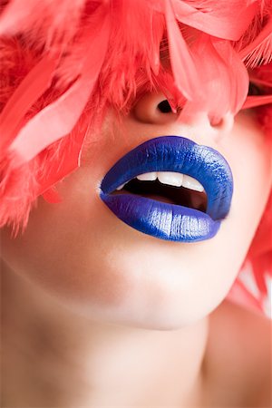 A woman wearing feathers and blue lipstick Stock Photo - Premium Royalty-Free, Code: 614-01757651