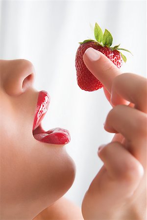 A woman holding a strawberry Stock Photo - Premium Royalty-Free, Code: 614-01757661