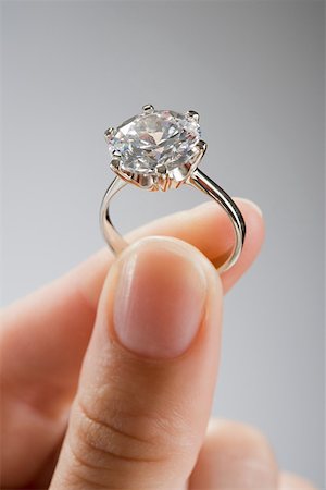 solitaire - Une femme tenant une bague de fiançailles Photographie de stock - Premium Libres de Droits, Code: 614-01758795