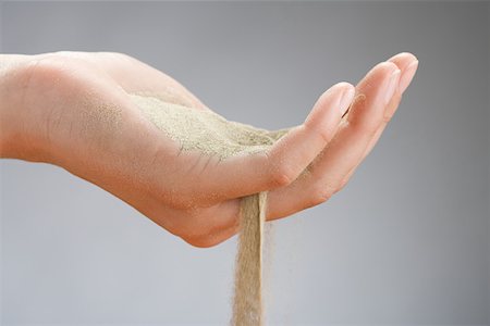 Sand falling through a womans hand Stock Photo - Premium Royalty-Free, Code: 614-01758799