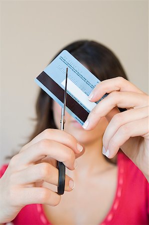 Woman cutting credit card Stock Photo - Premium Royalty-Free, Code: 614-01820451