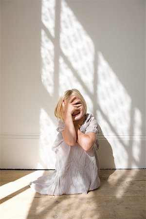 Girl covering her face with her hand Stock Photo - Premium Royalty-Free, Code: 614-01821701