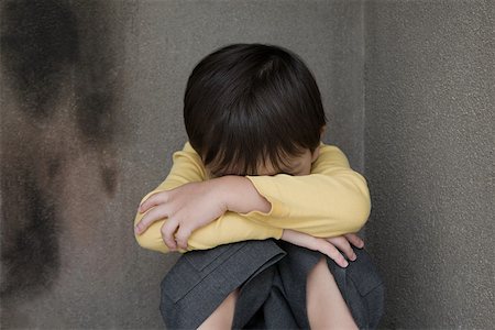 sitting sad boy - Boy crying in a corner Stock Photo - Premium Royalty-Free, Code: 614-01821723