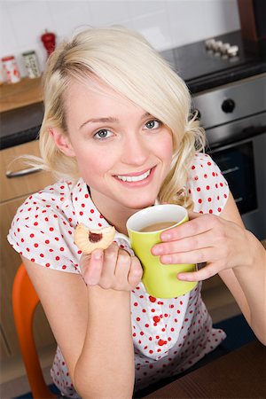 Woman having a cup of tea and a biscuit Stock Photo - Premium Royalty-Free, Code: 614-01869254