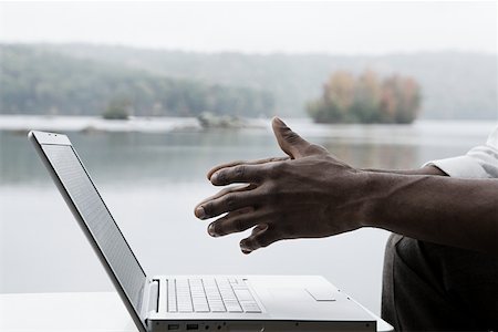 single man in arm of nature - A mans hands and a laptop Stock Photo - Premium Royalty-Free, Code: 614-01869337